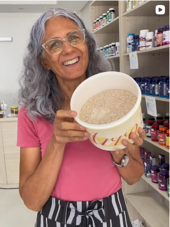 Joana Teles, proprietária da Viva Natural, sorrindo enquanto segura um pote de produto à granel